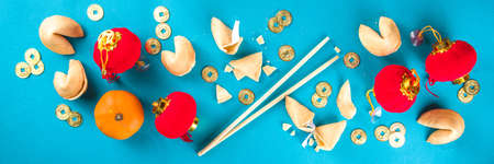 Chinese new year background. Red and golden yellow flatlay with traditional Chinese new year decor, envelopes with wishes, gold coins, fans, Chinese lanterns, oranges and teaの写真素材