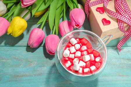 Heart shaped cup with red velvet hot chocolate, with small marshmallows, gift box and flowers for...