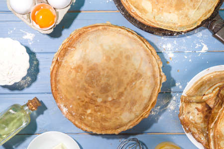 Russian Ukrainian European holiday Maslenitsa. Traditional thin crepes pancakes, on wooden blue...