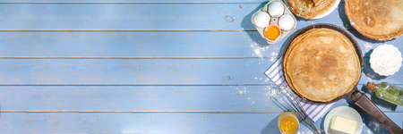 Russian Ukrainian European holiday Maslenitsa. Traditional thin crepes pancakes, on wooden blue...