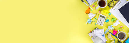 Brainstorming office table background. Office work table with notepads, pens, pencils, crumpled colorful paper, office supplies. creative business team brainstorming concept flat lay yellow backgroundの写真素材