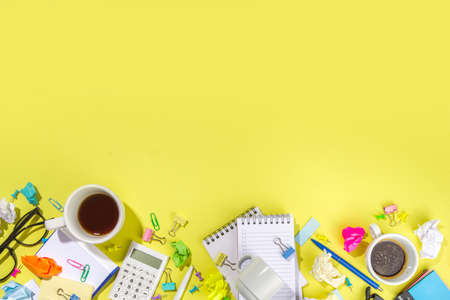 Brainstorming office table background. Office work table with notepads, pens, pencils, crumpled colorful paper, office supplies. creative business team brainstorming concept flat lay yellow backgroundの写真素材