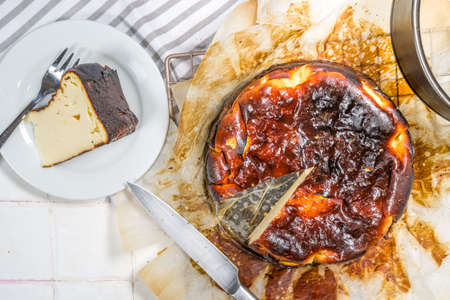 Homemade Burnt Basque Cheesecake, Piece of Basque burnt cheesecake with berry decor and whole cake....