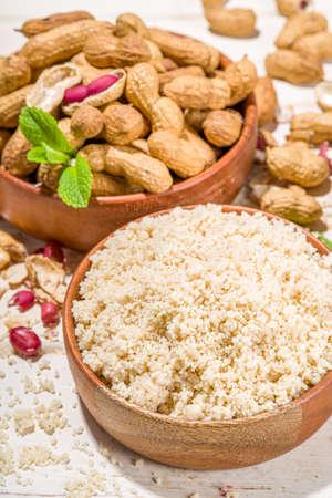 Alternative keto diet gluten grain free flour. Paleo and ketogenic diet baking cooking concept. Peanut flour with whole nutsの写真素材