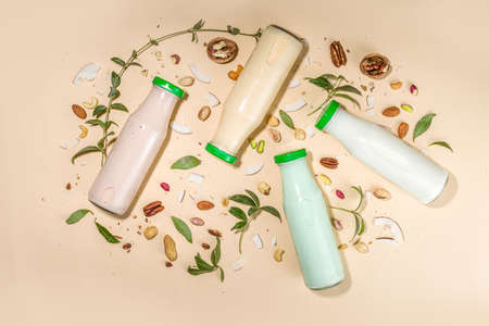 keto, paleo and vegan diet concept. Set of nut milks, bottles with various non-dairy nut milk - pistachio, walnut, hazelnut, peanut, almond, cashew, pecan, brazil nut, seeds, coconutの写真素材