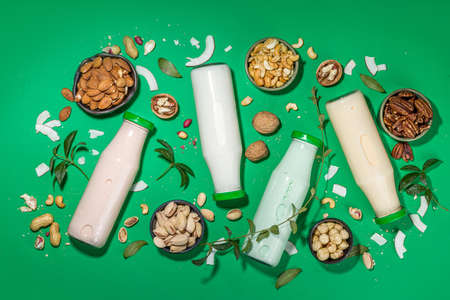 keto, paleo and vegan diet concept. Set of nut milks, bottles with various non-dairy nut milk - pistachio, walnut, hazelnut, peanut, almond, cashew, pecan, brazil nut, seeds, coconutの写真素材