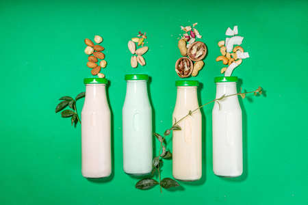 keto, paleo and vegan diet concept. Set of nut milks, bottles with various non-dairy nut milk - pistachio, walnut, hazelnut, peanut, almond, cashew, pecan, brazil nut, seeds, coconutの写真素材