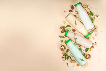 keto, paleo and vegan diet concept. Set of nut milks, bottles with various non-dairy nut milk - pistachio, walnut, hazelnut, peanut, almond, cashew, pecan, brazil nut, seeds, coconutの写真素材