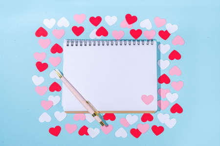 Valentine day simple greeting card flatlay. Valentines holiday background with red, pink, white hearts, pink roses, gift box, top view copy space on light blue backgroundの写真素材