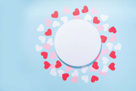 Valentine day simple greeting card flatlay. Valentines holiday background with red, pink, white hearts, pink roses, gift box, top view copy space on light blue backgroundの写真素材