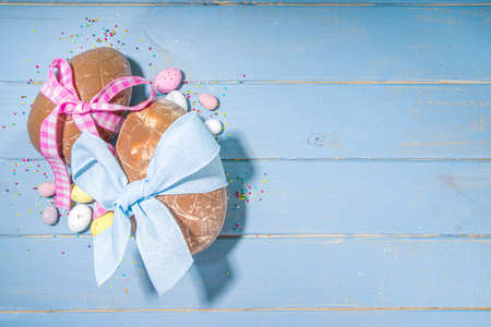 Easter holiday greeting card background, with chocolate easter bunny, eggs, and tulip flowers, on...