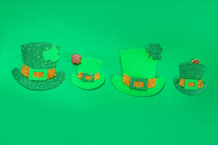 St Patrick flatlay background with shamrock clover leaves, leprechaun hat decor, golden coins and...