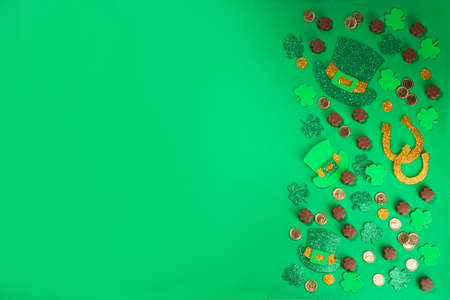 St Patrick flatlay background with shamrock clover leaves, leprechaun hat decor, golden coins and...