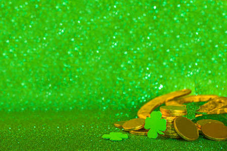 Saint patrick's day greeting background. Patrick's day sale, invitations template, menu. With holiday symbols - golden horseshoe, green clover, leprechaun hat, gold coins, green bokeh backgroundの写真素材