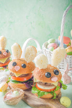 Delicious fresh homemade bunny burgers for Easter kids party. Creative burgers in the form of rabbits, with funny rabbit muzzle and ears, with Easter decor copy spaceの写真素材