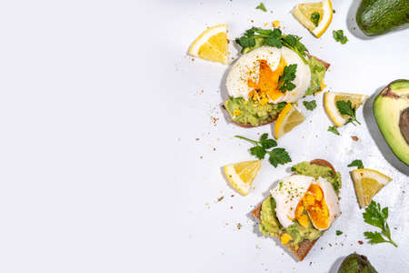 Healthy diet sandwiches for breakfast, snack. Toast with guacamole avocado salsa and poached eggの写真素材