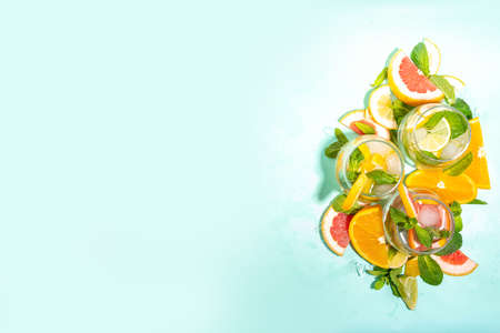 Summer healthy cocktails, mocktails. Set of various citrus lemonades mojito, with lime, lemon, orange, grapefruit, diet detox beverages on light blue turquoise background copy spaceの写真素材