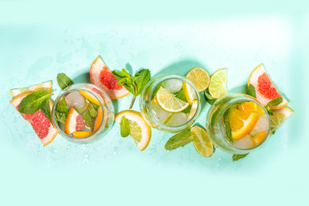 Summer healthy cocktails, mocktails. Set of various citrus lemonades mojito, with lime, lemon, orange, grapefruit, diet detox beverages on light blue turquoise background copy spaceの写真素材