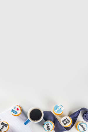 Happy Father's Day greeting card. Greetings and presents for Dad's day - gift box, coffee tea cup, tie, homemade special cupcakes.の写真素材