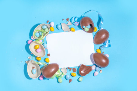 Happy Easter colorful flatlay. Bright high-colored and chocolate Easter eggs with festive holiday ribbon on blue background. Promotion and shopping template for Easterの写真素材