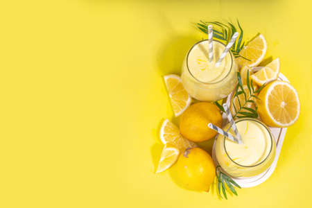 Creamy lemon fruit smoothie, yogurt ar milkshake, Sour sweet drink with fresh lemons on white yellow background copy spaceの写真素材