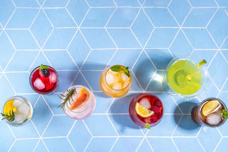 Summer bar cocktail menu. Set of different glasses variations of drinks, mocktails, cocktails, sparkling refreshing beach water. Citrus and fruit drinks with garnish and ice cubes copy spaceの写真素材