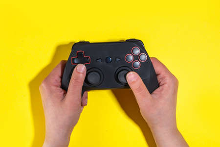 Gaming concept with various gamers devices on bright yellow background - gamepad joystick, keyboard,...