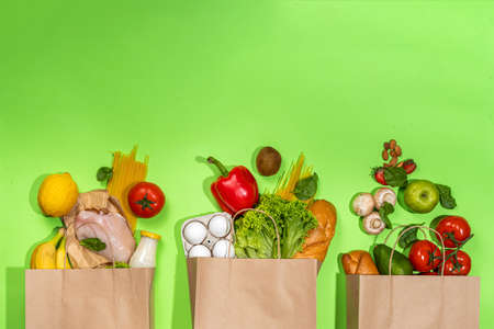 Fresh vegetables, meat, bread fruits in paper grocery bag. Delivery healthy food background. Healthy food cooking ingredients on white,background, Shopping food supermarket and clean vegan eatingの写真素材