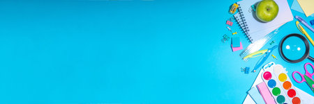 Flat lay background with colorful educational supplies on bright blue background. Back to school...