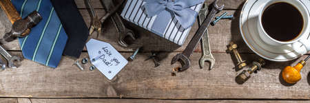 Father day greeting card background. Fathers day concept with gift box, tools and ties, coffee cup, gift tag Love you dad, on rustic wooden background top view copy spaceの写真素材