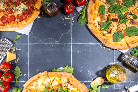 Three various pizzas, served at home or in restaurant on tiled table with cooking ingredients, tomato, basil, spinach, arugula Classic pepperoni pizza, vegetarian vegetable and seafood shrimp pizza,の写真素材