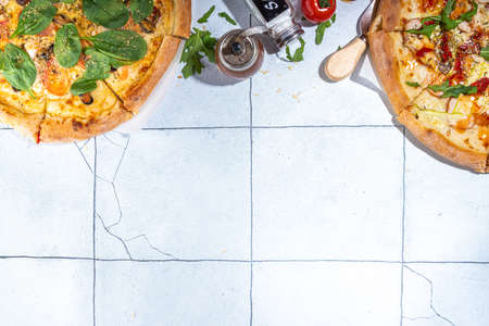 Three various pizzas, served at home or in restaurant on tiled table with cooking ingredients, tomato, basil, spinach, arugula Classic pepperoni pizza, vegetarian vegetable and seafood shrimp pizza,の写真素材