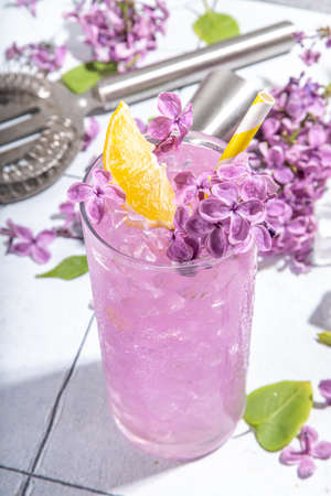 Lilac drink. Alternative organic natural cocktail or mocktail, infused drink from lilac flowers. Lilac lemonade with ice in a tall long glass.の写真素材