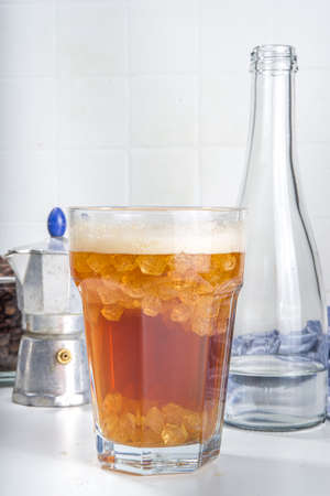 Fizzy coffee drink. Coffee espresso with carbonated mineral water and crushed ice, with coffee maker, milk roasted coffee beans on white background copy spaceの写真素材