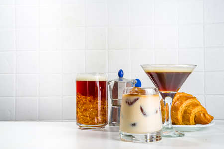 Set of three coffee drinks in various cocktails glasses, on white background copy spaceの写真素材