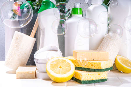 Eco friendly organic cleaning concept. Eco-friendly cleaner utensils - eco brushes, tools sponges, natural cleaning products, soda, soap, lemon, vinegar, bottles with green leaves on white backgroundの写真素材