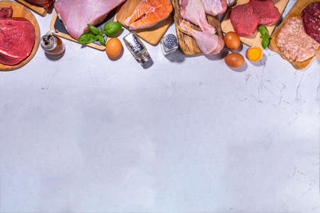 Carnivore diet background. Various non-vegan protein sources, Traditional Carnivore food - meat and fish, chicken breast, pork steak, beef steak, patty, heart, liver, eggs with spices for cookingの写真素材