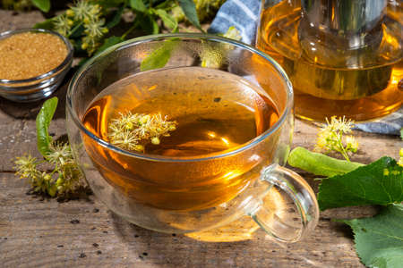Herbal linden flower tea. linden green tea in glass teapot and tea cup, with fresh linden blossomの写真素材