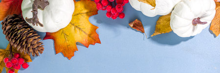 Thanksgiving day, Halloween festive geetiing card with pumpkins, decorative berries and autumn leaves on turquoise blue table copy space. fall holiday flat lay copy spaceの写真素材