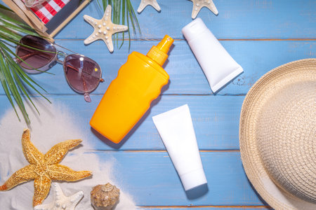 Sunscreen suncare background. Mockup background with vacation accessory, suntan lotion bottle, cosmetic cream, with seashells, straw woman's hat with sun glasses, top view copy spaceの写真素材
