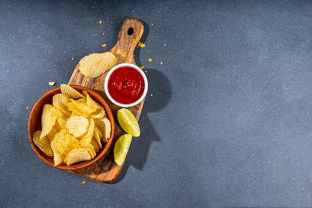 Various unhealthy salty bar snacks set. Dark gray table background with traditional party snacks -...