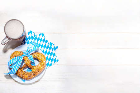 Oktoberfest holiday background, menu mockup. Bavaria flag oktoberfest festival napkin, pretzel, beer bottle and mug on white wooden background, copy space top viewの写真素材