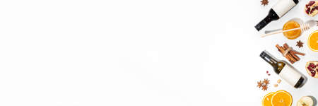 Different mulled wine ingredients set on white background, flat lay with wine bottle, cinnamon, apple, orange, anise star, simple autumn food drink cooking backgroundの写真素材