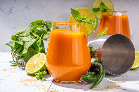 Carrot Ginger Margarita cocktail with lime, mint and hot chili pepper, original vegetable spicy drink on white tiled background copy spaceの写真素材