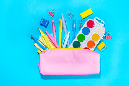 Back to school flat lay background. Pink pencil case with various school stationery on high-colored bright backgroundの写真素材
