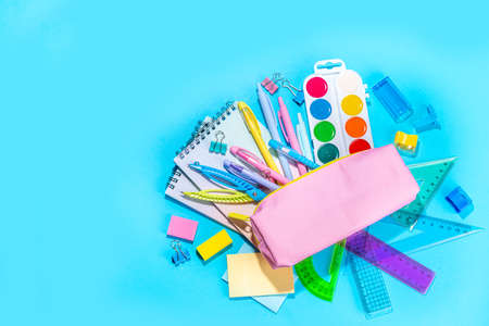 Back to school flat lay background. Pink pencil case with various school stationery on high-colored bright backgroundの写真素材