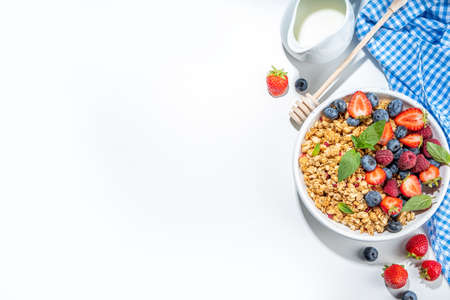 Healthy breakfast granola with fresh berry - strawberry, raspberry, blueberry on white backgroundの写真素材