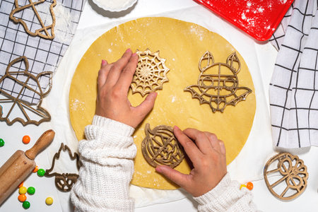 Halloween cooking background. Making cookies for Halloween party treats on white kitchen table, with...