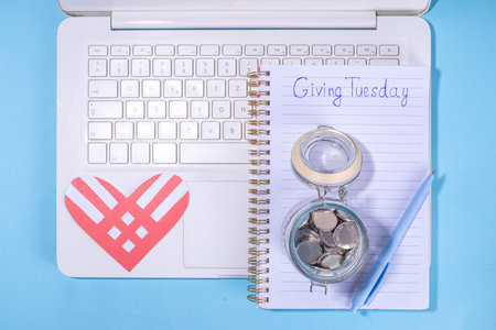 Giving Tuesday background, global day of charitable action, giving, donations. after Black Friday shopping day. Charity, give help, donations support day with coins jar, red heart, laptop, gift boxの写真素材