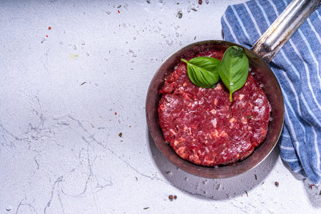 Raw beef burger cutlet with spices for cooking. Raw beef burger cutlet, minced red meat cooking background copy space top viewの写真素材